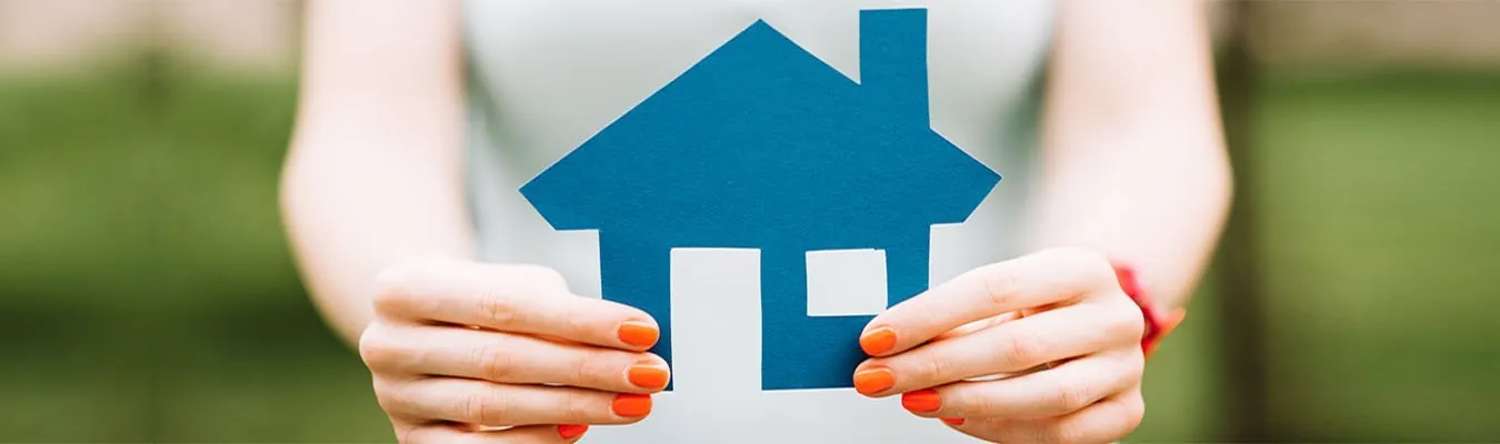 Paper house held in two hands for housing loans